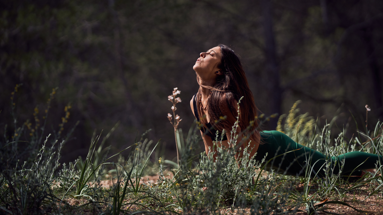 women in field in yoga pose