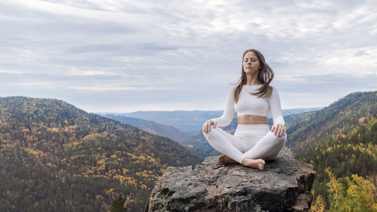 woman at top of mountain in meditation.