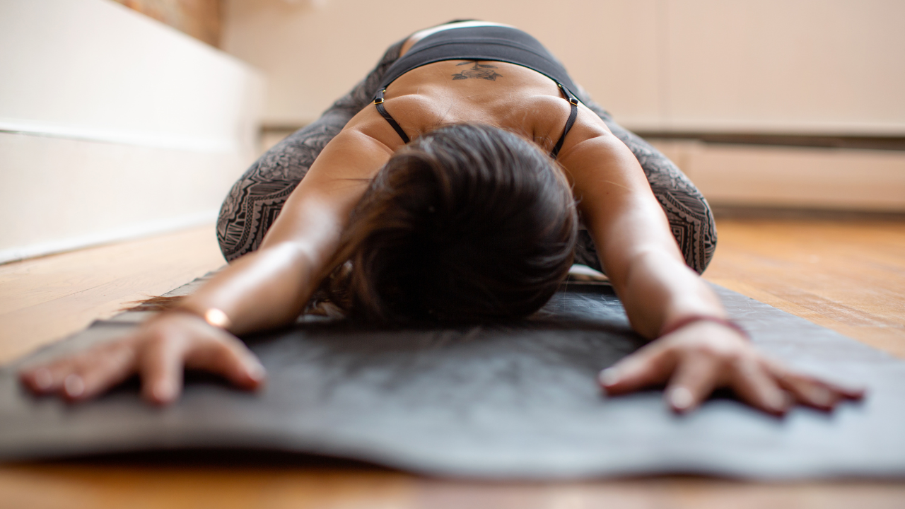 Person practicing yoga on a mat indoors